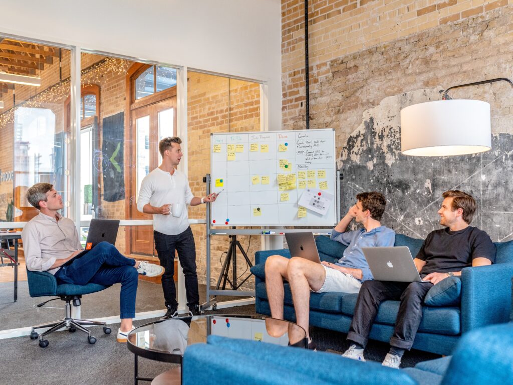 people in an office in front of a whiteboard